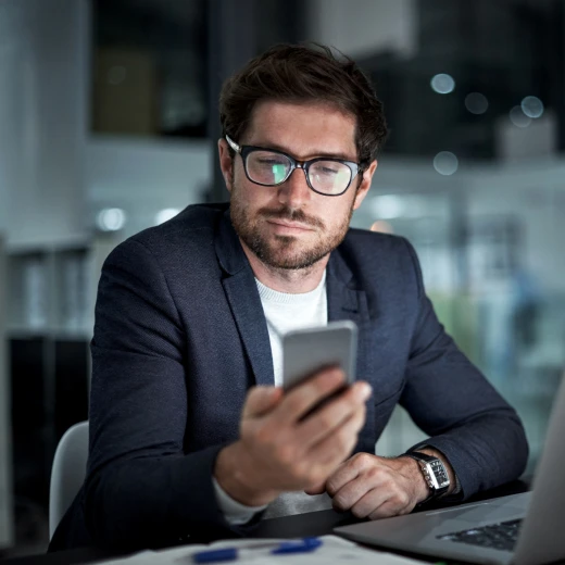 homem usando terno e mexendo no celular